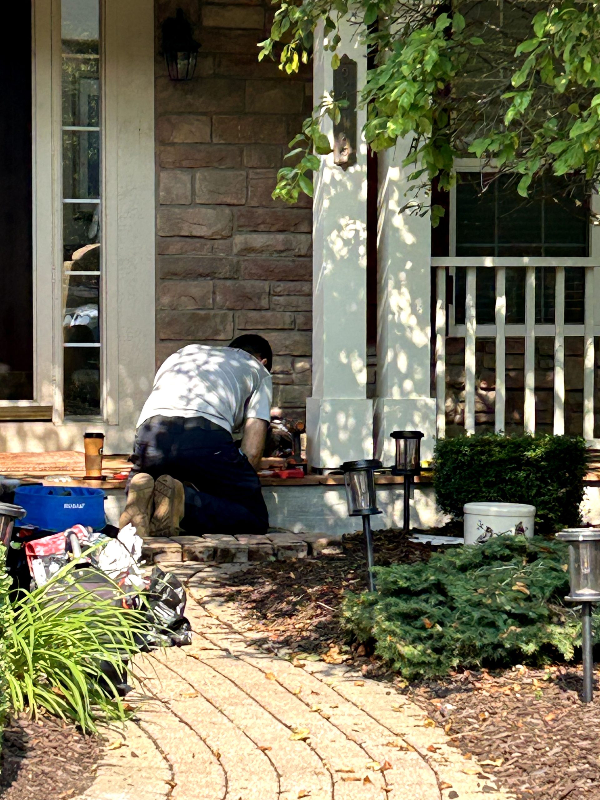 A man is diligently working on the ground to improve a house, showcasing his commitment to home renovation