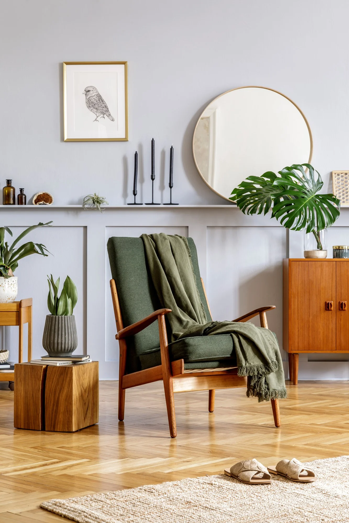 A bright living room showcasing a green chair, an elegant mirror, and a vibrant plant, enhancing the space's charm