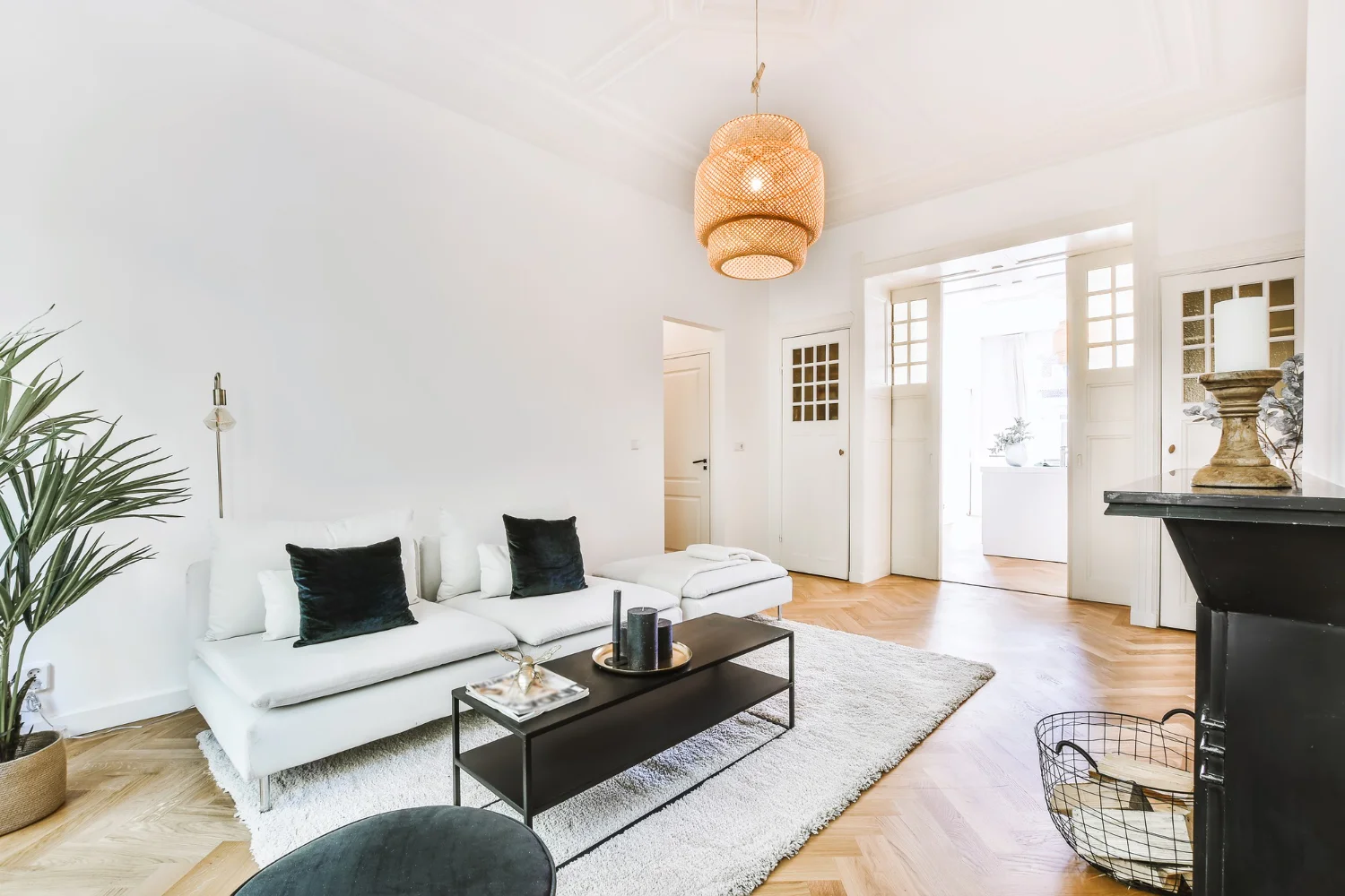 A modern living room with sleek white furniture and beautiful wooden floors, creating a cozy atmosphere